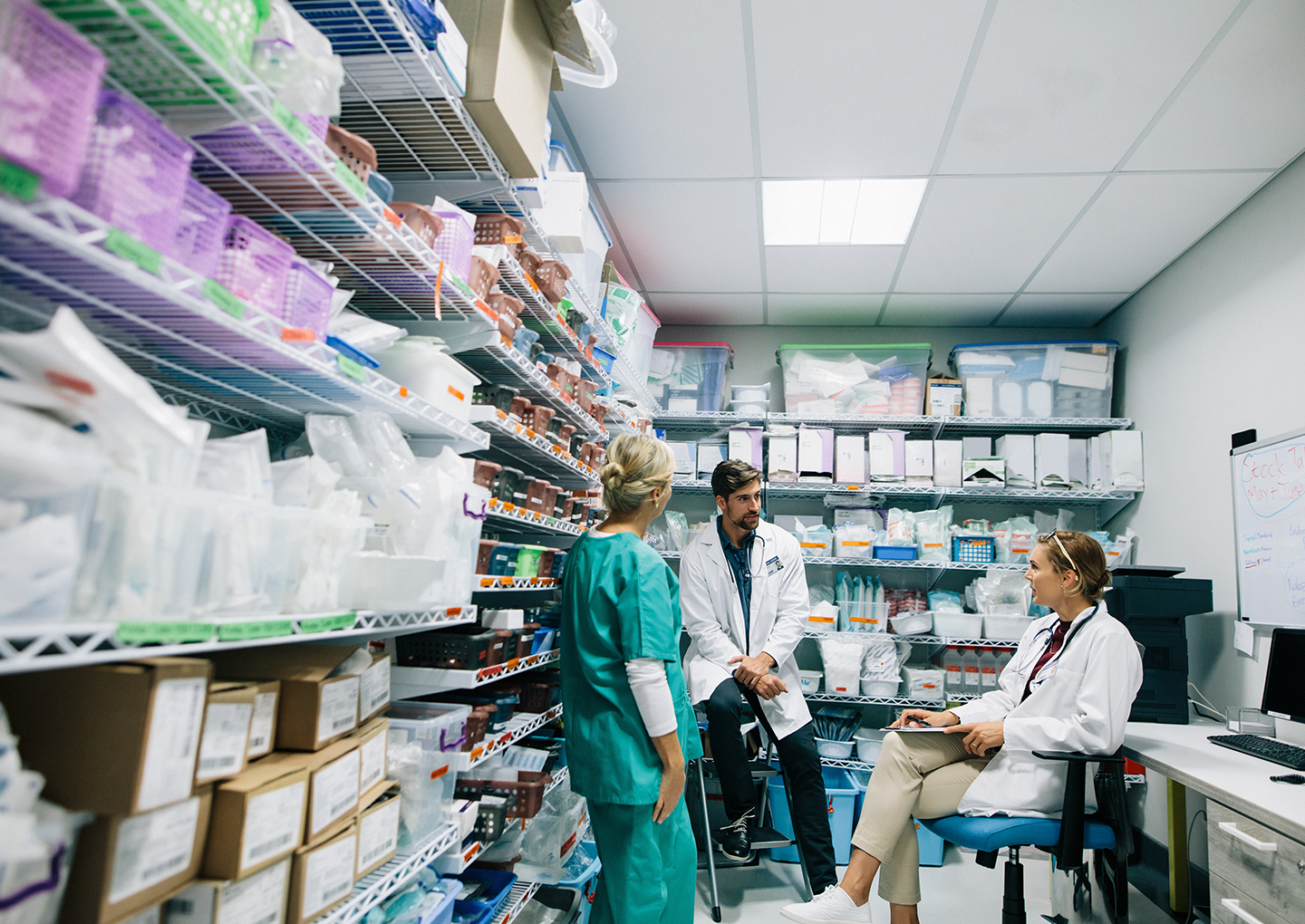 People in healthcare office stockroom